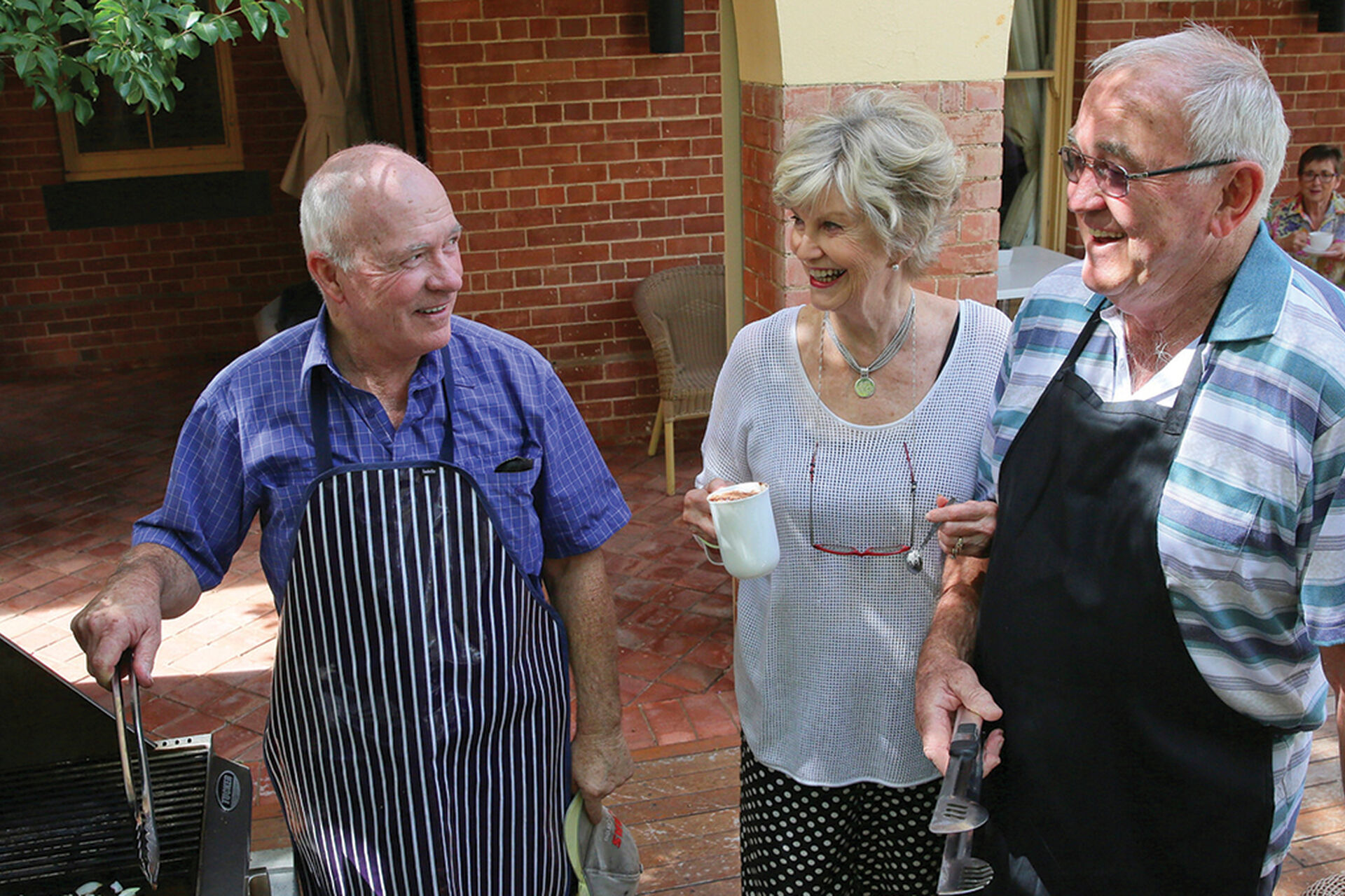 over 55s enjoying cooking a bbq together at their retirement village in Wagga Wagga baptistcare Watermark village