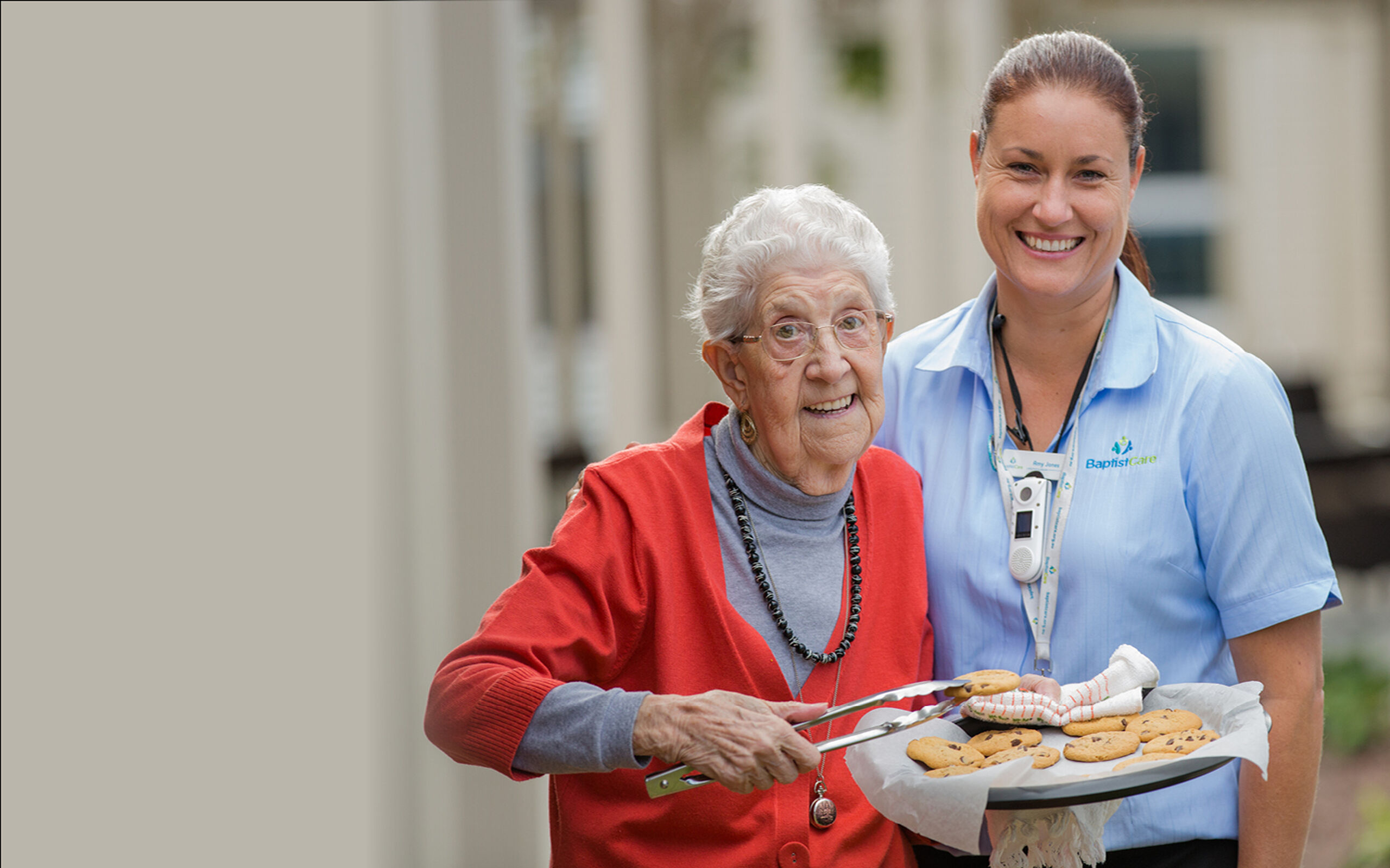 baptistcare residential aged care resident serving cookies with aged care employee