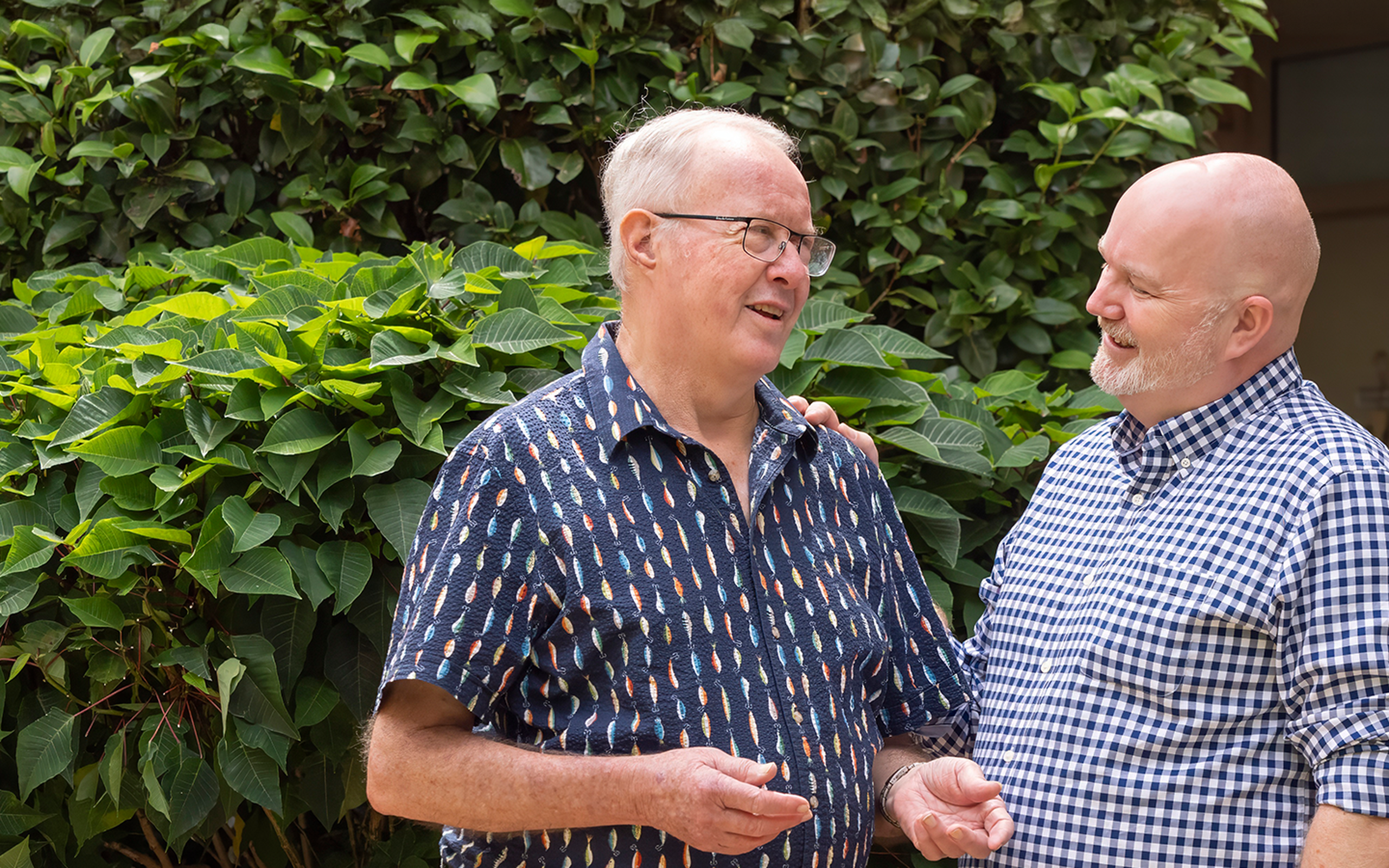 senior aged care resident smiling with a baptistcare aged care chaplain outside of the nursing home