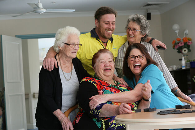 baptistcare residential aged care resident with family visiting and aged care worker hugging resident
