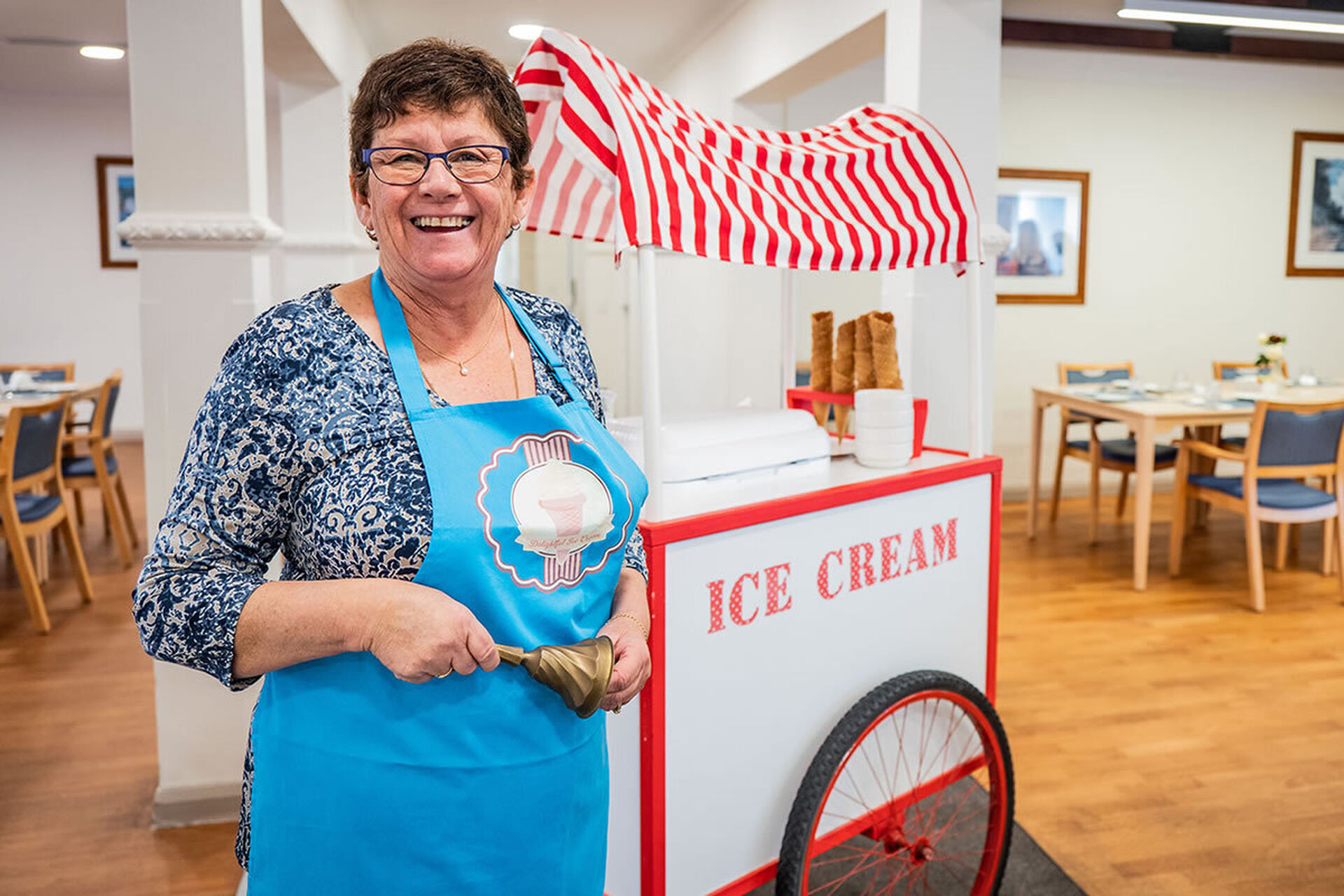 a nursing home volunteer serving ice cream at baptistcare graceford aged care home in byford wa