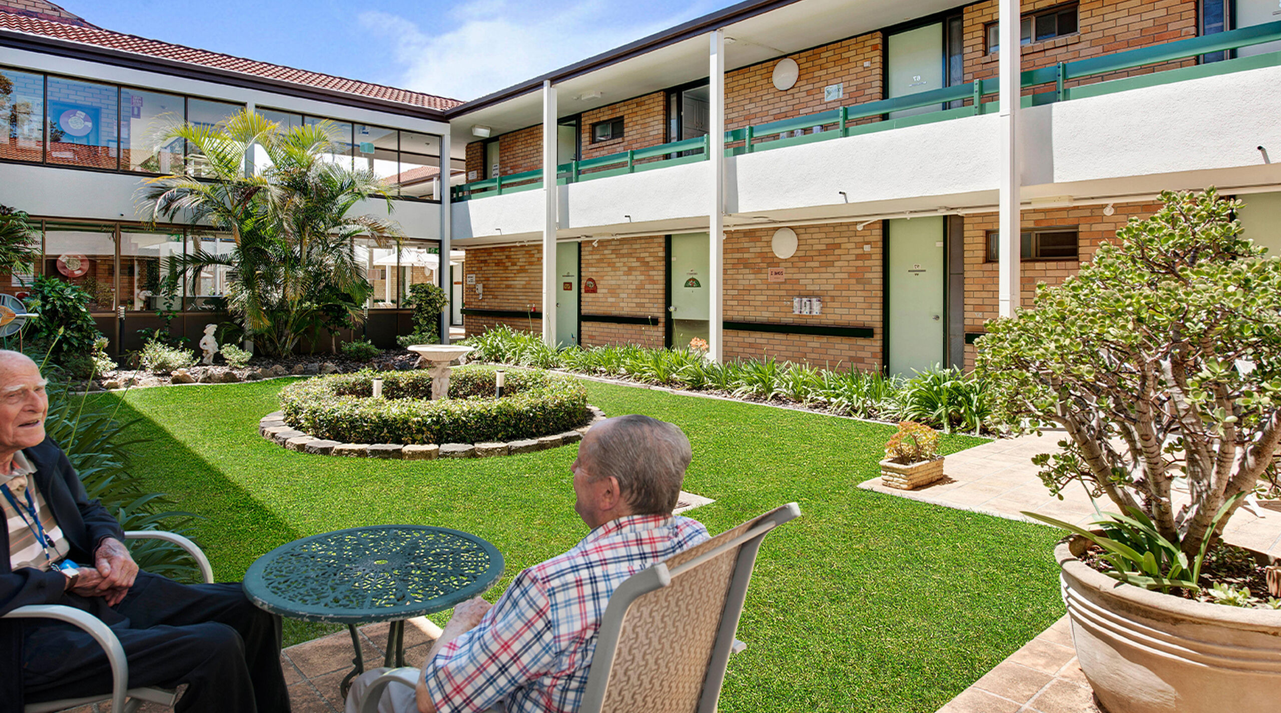 two residential aged care residents socialising in the gardens of baptistcare amimya centre aged care home
