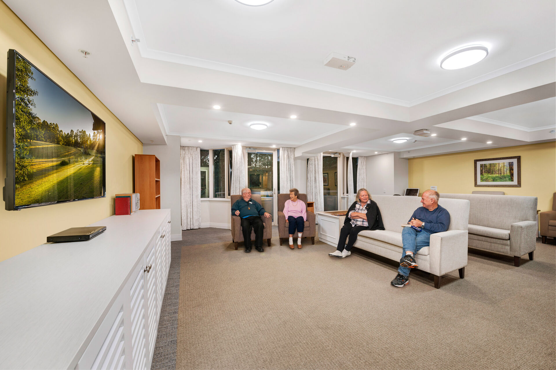 spacious communal lounge room with couches for aged care residents to socialise and watch television at baptistcare orana centre aged care home in point clare nsw central coast