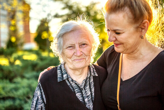 elderly aged care home dementia resident outside with her baptistcare care service employee embracing her at baptistcare caloola centre nursing home wagga wagga nsw