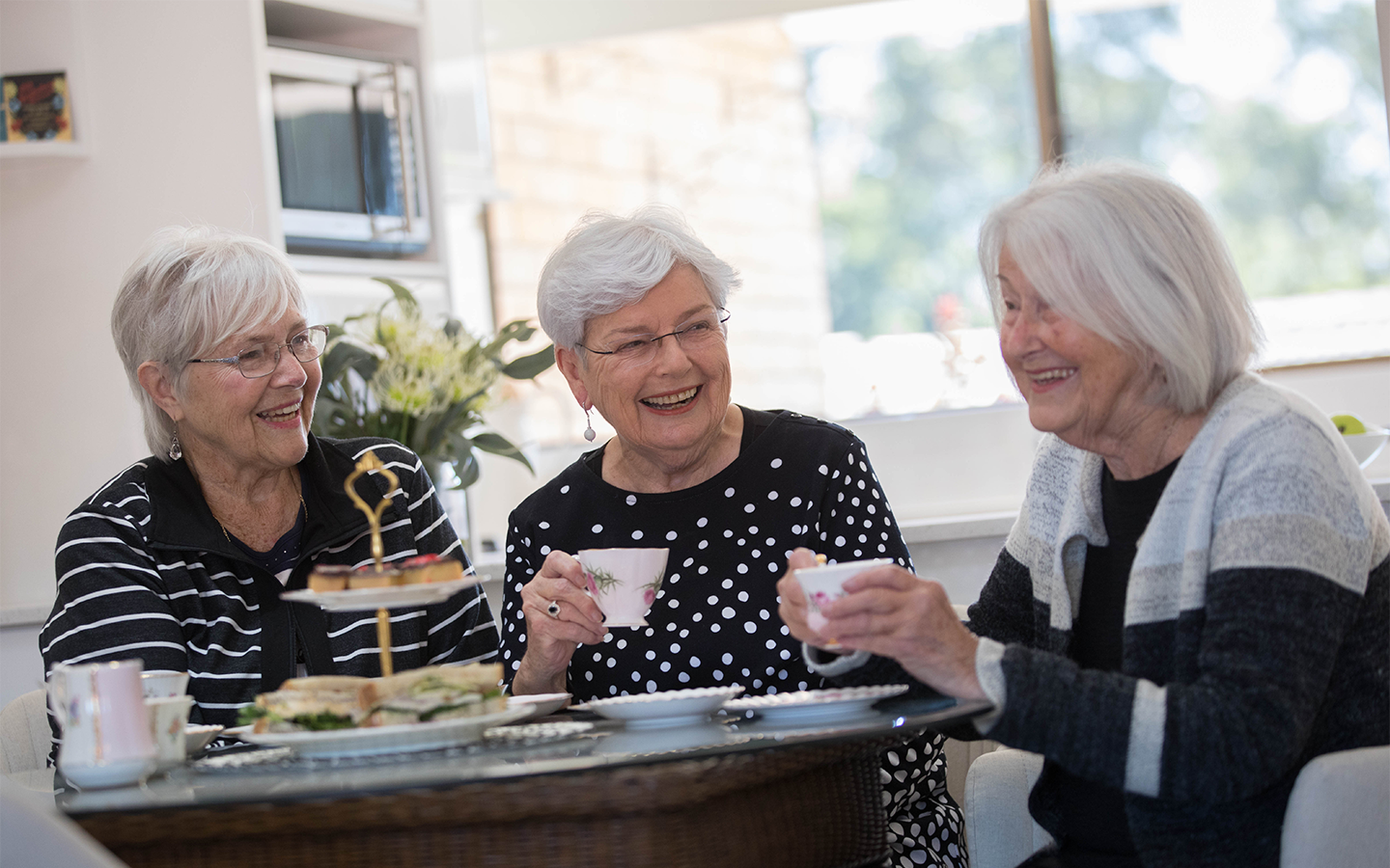 three over 55s women enjoying independent living in baptistcare retirement village socialising and having a meal during their retirement
