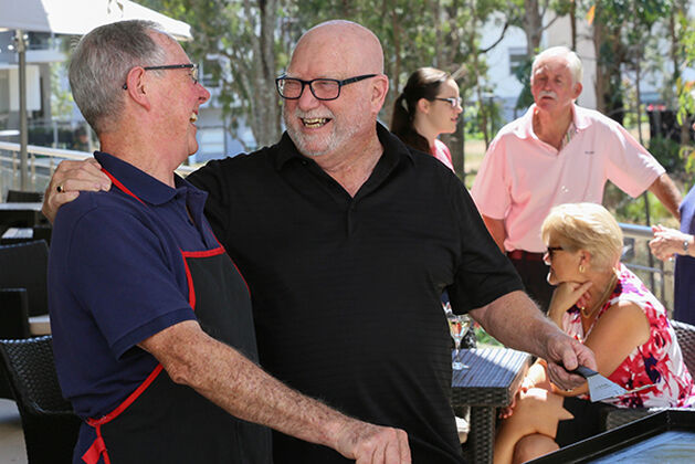 two men enjoying cooking a bbq on the balcony of the retirement village community centre baptistcare the grange wagga wagga
