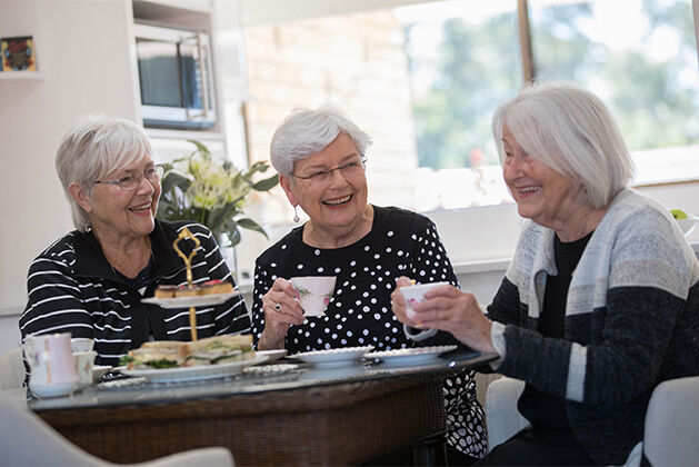 three over 55s ladies enjoying tea in the community centre of the retirement village after downsizing baptistcare Watermark village
